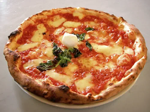 A classic Neapolitan pizza Margherita with browned, blistered mozzarella and a charred crust